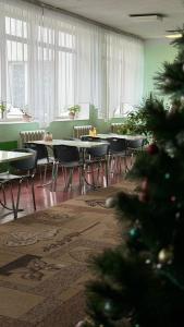 ein Zimmer mit Tischen und Stühlen und einem Weihnachtsbaum in der Unterkunft Sanatoriy Samara 