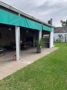 a patio with a green awning and a table and chairs at Casa Norte in Concordia