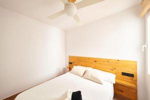 Un dormitorio con una cama y un ventilador de techo. en Bogavante, en La Isleta del Moro