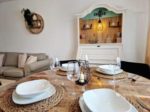 a dining room table with plates and wine glasses at Sonnenhang im Boho-Stil mit Balkon, 500m zum See, 2 Schlafzimmer in Möhnesee +46 photos