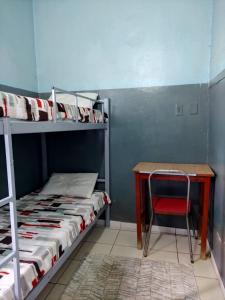 a room with a desk and a bunk bed and a chair at fiori centro in Brasilia