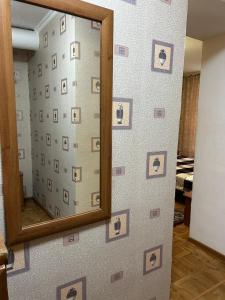 a mirror on a wall with a wall covered in photos at Economy - class apartment in Pavlodar