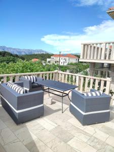 a patio with two couches and a table on a balcony at Apartments Glavinović - Near Beach and Center, Free Parking in Povlja