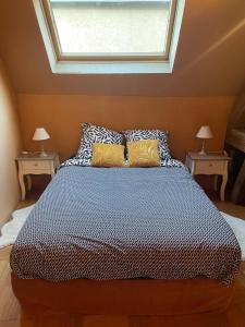 Un dormitorio con una cama grande con dos mesas. en Maison Saint Pierre, en Chartres