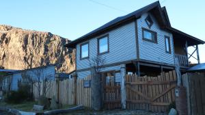 una casa con una valla delante de una montaña en CasaAndina Chalten, en El Chaltén