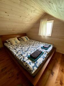 a bed in a log cabin with a window at Agroturystyka przy Pracowni Malarstwa i Rzeźby in Opinogóra Górna