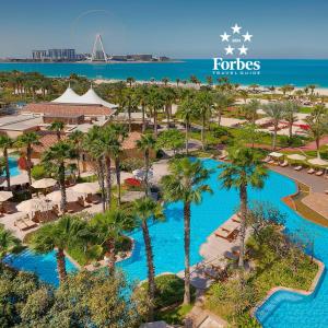 an aerial view of a resort with palm trees and a pool at The Ritz-Carlton, Dubai in Dubai