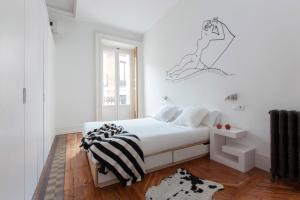a white bedroom with a bed and a window at Apartamentos Matute 11 in Madrid