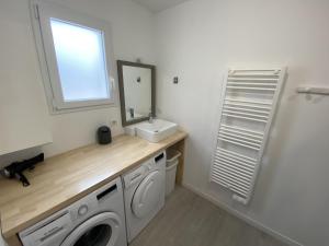 a bathroom with a washing machine and a sink at Maison de plein pied proche mer, marais et foret in Olonne-sur-Mer