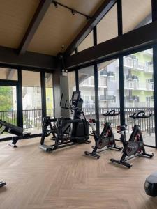 a gym with treadmills and ellipticals in a building at 212B Amani Grand Resort Residences near Mactan Airport with pool, gym, wifi, netflix in Pusok +28 photos