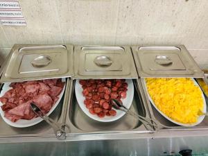 a group of bowls of food with meat and cheese at Hotel Colmeia in Monte Real