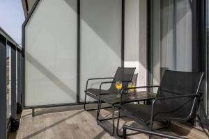two black chairs and a table on a balcony at Eleganckie Studio Basen, Fitness & Balkon by Noclegi Renters in Dziwnów