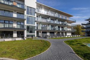 an apartment building with a walkway in front of it at Eleganckie Studio Basen, Fitness & Balkon by Noclegi Renters in Dziwnów