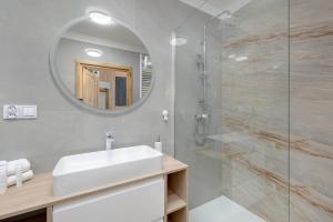 a bathroom with a sink and a mirror at Eleganckie Studio Basen, Fitness & Balkon by Noclegi Renters in Dziwnów