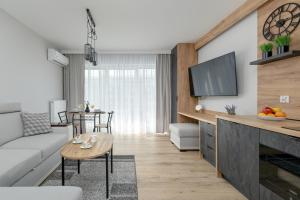 a living room with a couch and a tv at Eleganckie Studio Basen, Fitness & Balkon by Noclegi Renters in Dziwnów +21 photos