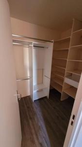 un dressing vide avec parquet et étagères dans l'établissement Appartement 58m2 lumineux en face du Parc des expositions, à Vanves