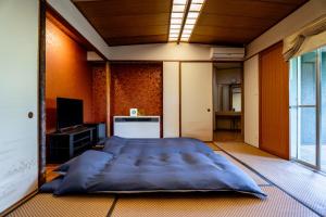 ein großes blaues Bett in einem Zimmer mit Fenster in der Unterkunft YuYu Hakone - Private Open Air Onsen Usage Guaranteed in Hakone