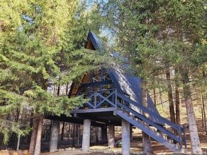 a blue tree house in the middle of trees at A frame Cuib de Vultur in Porumbacu de Sus