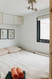 a bedroom with a bed with two towels on it at Tiny Cabin Mae op de Veluwe in Putten