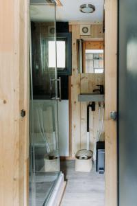 a bathroom with a glass shower and a sink at Tiny Cabin Mae op de Veluwe in Putten