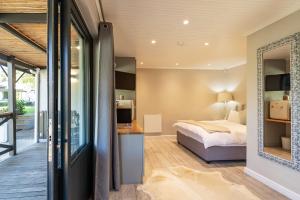 a bedroom with a bed and a mirror at Novelle Vista Cottage in Hout Bay