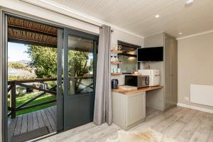 a kitchen with a microwave and a sliding glass door at Novelle Vista Cottage in Hout Bay +40 photos
