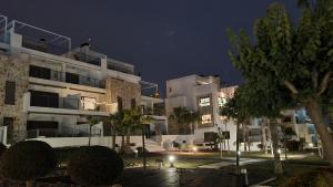ein großes Mehrfamilienhaus bei Nacht mit Bäumen davor in der Unterkunft Casa Marysol in Orihuela