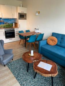 un soggiorno con un divano blu e un tavolo di Aquamarina 17 a Heiligenhafen