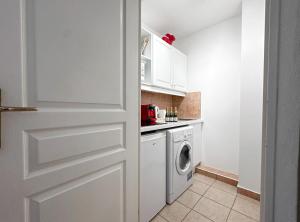 a kitchen with a washer and dryer next to a door at Palais Josephine 1BR Bnbrickeys in Beausoleil