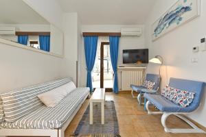 een woonkamer met een bank en twee stoelen bij Apartments Zeljka 1787 in Vodnjan