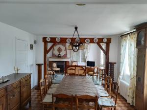 a dining room with a long table and chairs at Gîte de Josapha in Fourmetot