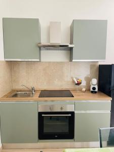 una cucina con mobili bianchi e un lavandino di la casetta di Max a Roma