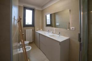 łazienka z umywalką, toaletą i lustrem w obiekcie VILLA FENIX MILANO w Mediolanie