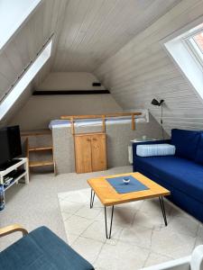 un soggiorno con un divano blu e un tavolo di Altes Zollhaus a Fehmarn
