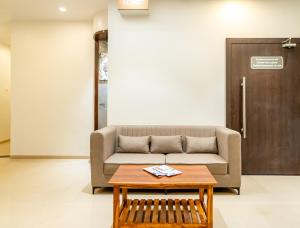 a living room with a couch and a coffee table at Itsy Hotels Sitara in Satara