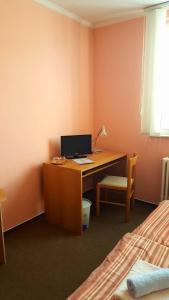 een slaapkamer met een bureau, een computer en een bed bij Penzion Premona in Nitra