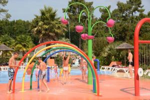 a group of people playing in a swimming pool at Mobil Homes Camping 4 étoiles Les Viviers in Lège-Cap-Ferret
