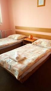 two beds in a hotel room with towels on them at Penzion Premona in Nitra