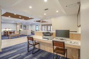 an office with a desk with a computer and two chairs at Holiday Inn Express Hotel & Suites Gulf Shores by IHG in Gulf Shores