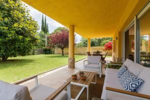 eine Terrasse mit weißen Stühlen und einem Tisch in der Unterkunft Casa con jardín próxima a Barcelona in Sant Andreu de Llavaneres