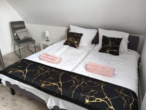 un grande letto con lenzuola e cuscini bianchi e neri di Apartamenty Przy Zamku - Noclegi Pasłęk a Pasłęk