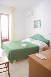 una camera d'albergo con due letti con lenzuola verdi di Hotel Cesotta a Ischia