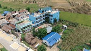 an aerial view of a blue building in a village at Hong Qi Hotel in Chitwan