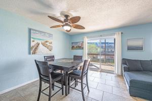 a dining room with a table and chairs and a couch at Bay Tree B78 in Port Aransas