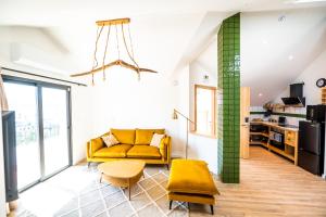 a living room with a yellow couch and a table at Mira D'Ouro Sertã in Sertã