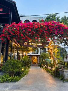 einen Gehweg mit Blumen, die von einem Gebäude hängen in der Unterkunft Eden Hotel Cát Bà in Cát Bà