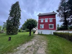 una casa rossa con un albero in un campo di Qouei Eichi la maison fleurie PISCINE Campagne a Bas-en-Basset