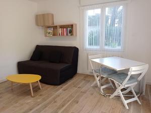 a living room with a couch and a table at Petite maison dans un écrin de verdure in Les Angles Gard