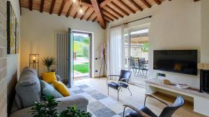 a living room with a couch and chairs and a tv at VILLINO LE MOIE 4&2, Emma Villas in Fermo
