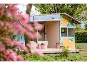 a tiny house with a porch in a yard at Parc Boulée in Ven-Zelderheide